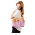 Load image into Gallery viewer, A woman with long red hair is standing and holding a colorful bag with multiple pockets and compartments.

