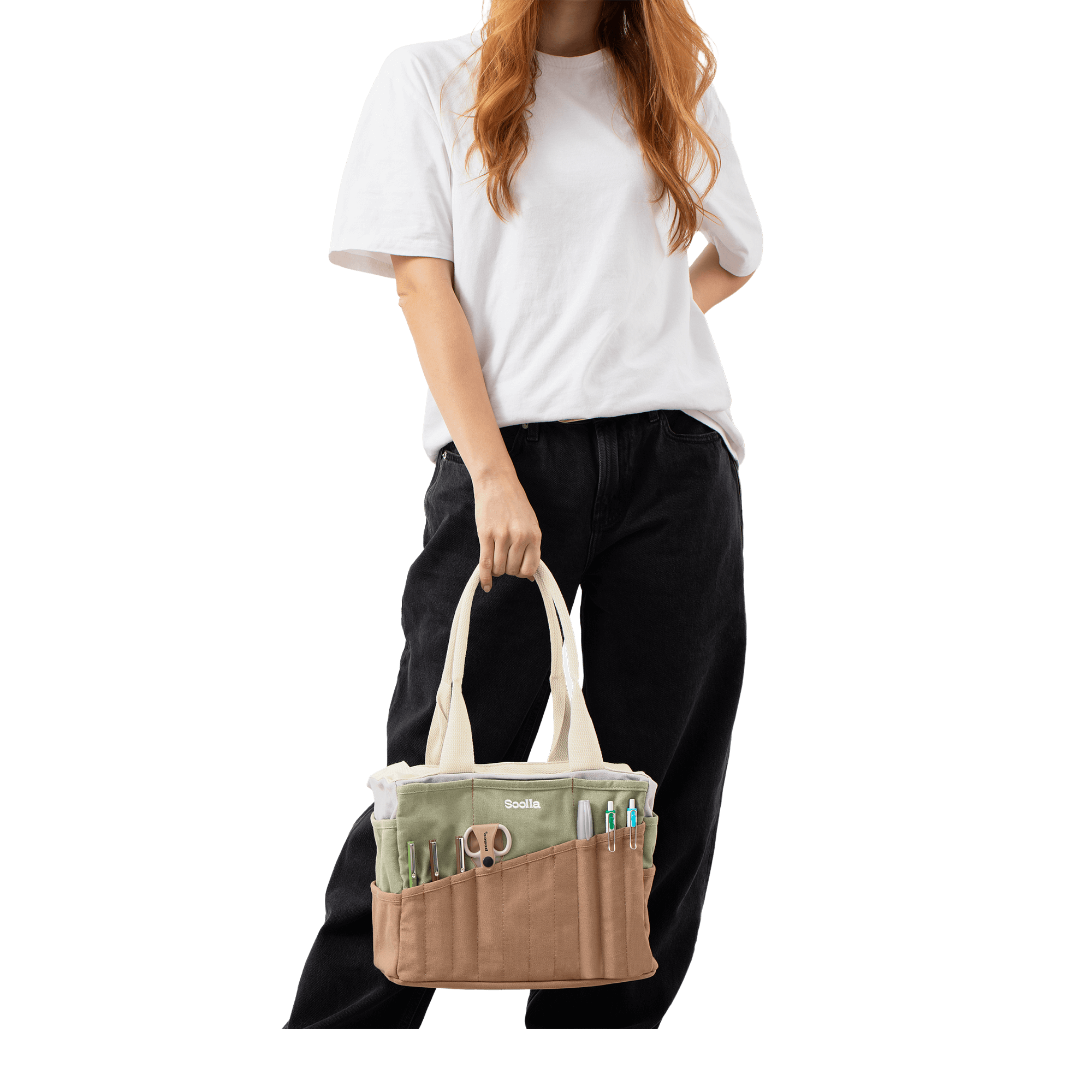 A person is standing against a black background, holding a bag with multiple compartments.